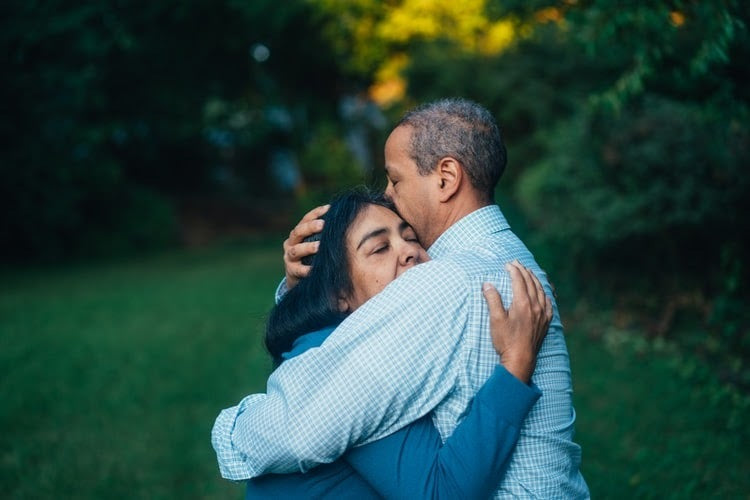 Older man embracing a young woman outdoors
