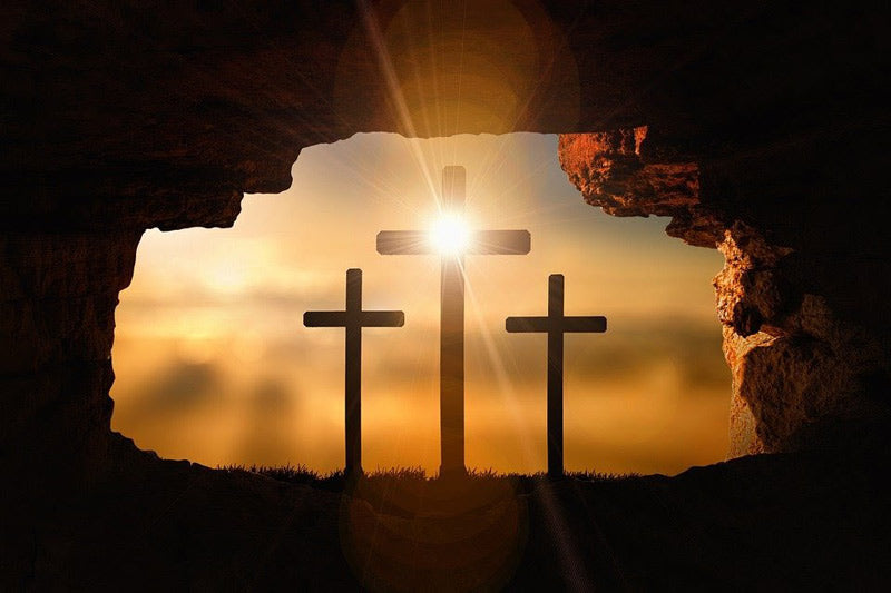 Three crosses standing outside a cave