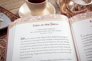 Open book with a quote on a wooden table with a cup of coffee.