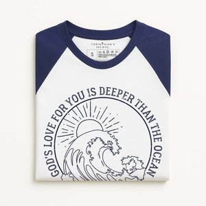 White and navy baseball shirt with ocean wave design and Biblical text on a white background