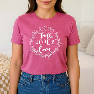 Woman wearing a pink t-shirt with 'Faith Hope Love' text