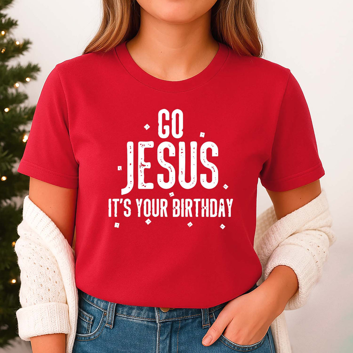 Woman wearing a red t-shirt with 'Go Jesus, It's Your Birthday' text in front of a Christmas tree.