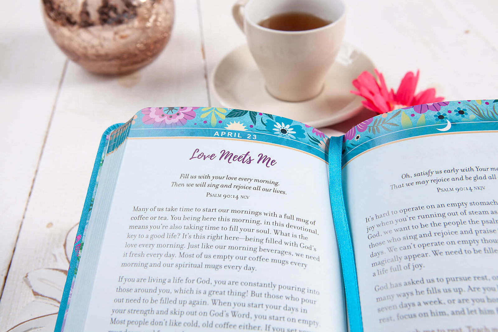 Blue devotional book with floral designs and 'God is my happy place' text on a decorative surface.