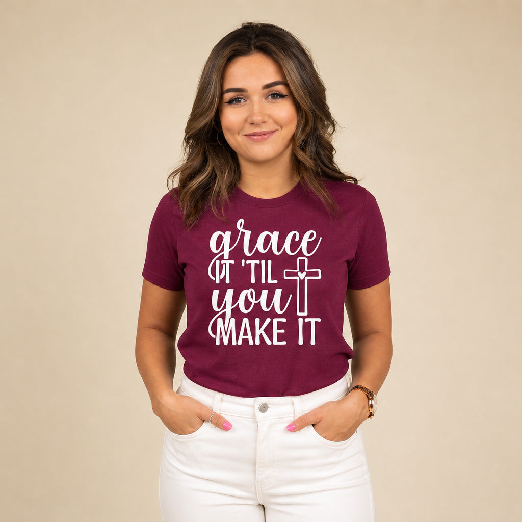 Woman wearing a maroon 'grace it til you make it' shirt with white pants