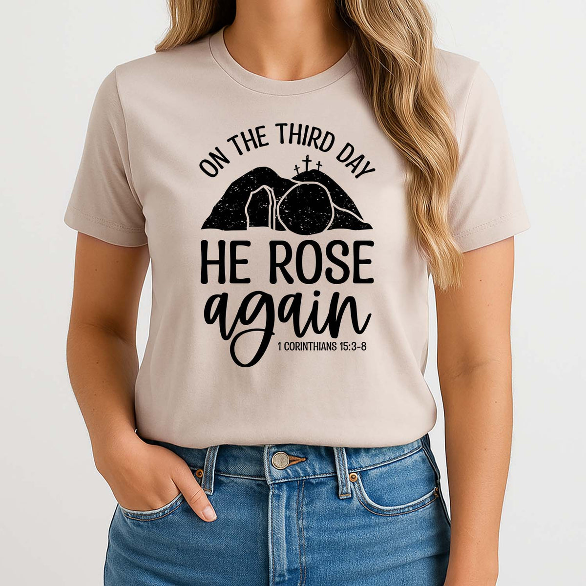 Woman wearing a beige t-shirt with a religious design and text from 1 Corinthians 15:3
