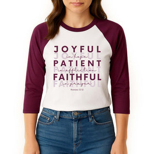 Woman wearing a maroon and white baseball shirt with Romans 12:12 Biblical inscription