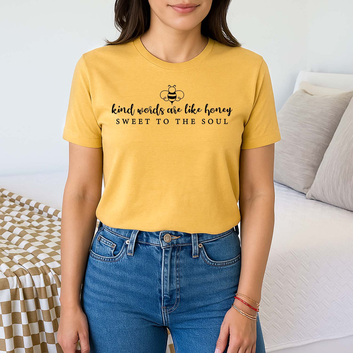 Woman wearing a yellow t-shirt with "kind words are like honey" quote in a casual setting