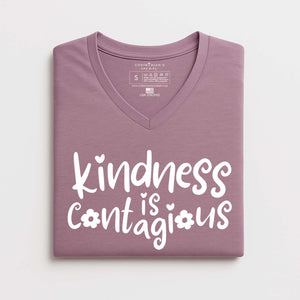 Folded purple t-shirt with 'kindness is contagious' text on a white background