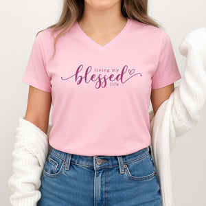 Person wearing a pink t-shirt with 'living my blessed life' text