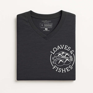 Folded black t-shirt with 'Loaves & Fishes' logo on a white background