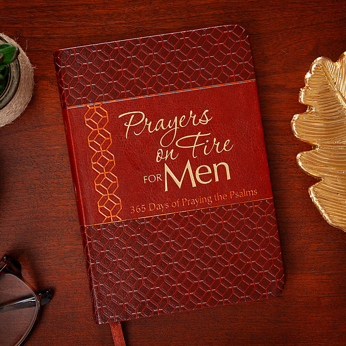 Red devotional titled 'Prayers on Fire for Men' on a wooden surface with decorative elements.