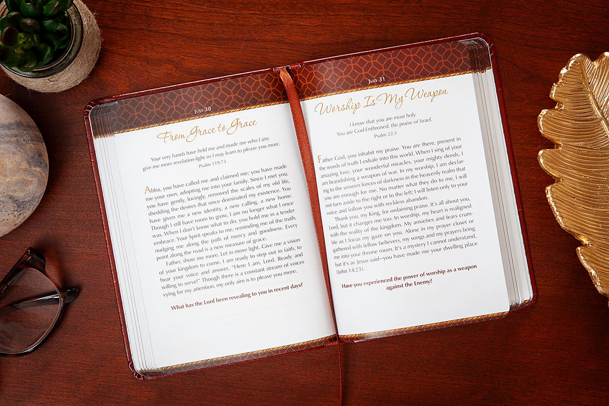 Open devotional with a decorative cover on a wooden surface