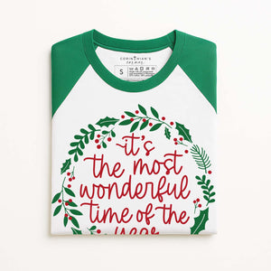 Christmas-themed t-shirt with green sleeves and festive text on a white background