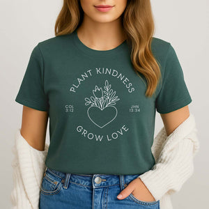 Woman wearing a green t-shirt with 'Plant Kindness, Grow Love' text and heart design.