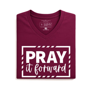 Folded maroon t-shirt with 'PRAY it forward' text on a white background