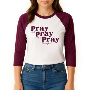 Woman modeling a maroon and white 3/4 sleeve shirt with 'Pray on it, pray over it, pray through it' text