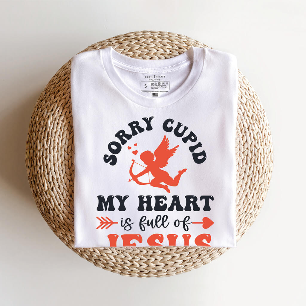 Folded white shirt that reads sorry Cupid my heart is full of Jesus