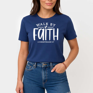 Woman wearing a blue t-shirt with 'Walk by Faith' text on a plain background