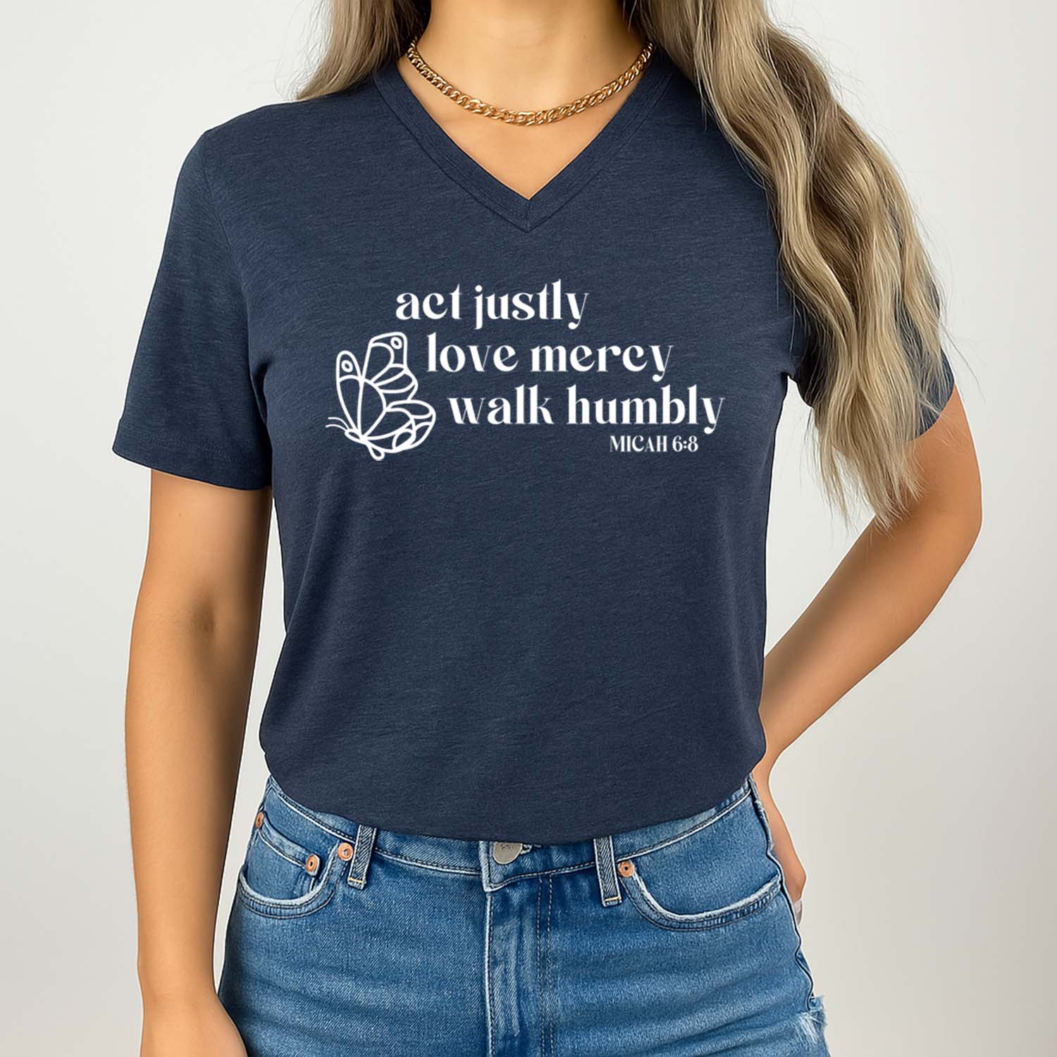 "Act justly, love mercy, walk humbly" design with a butterfly on a navy V-neck shirt