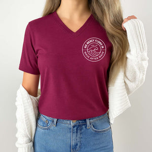 Woman wearing a maroon t-shirt with a logo that reads His mercy flows in wave after wave