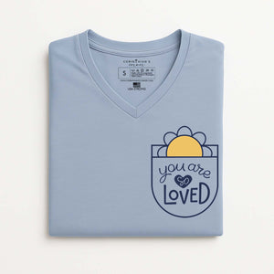 Folded light blue t-shirt with 'you are loved' design on a white background