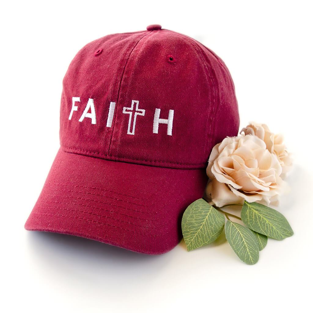 Red dad hat with white embroidery that reads faith