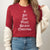 A festive 'Joy Love Peace Believe Christmas' design in white on a cardinal long sleeve