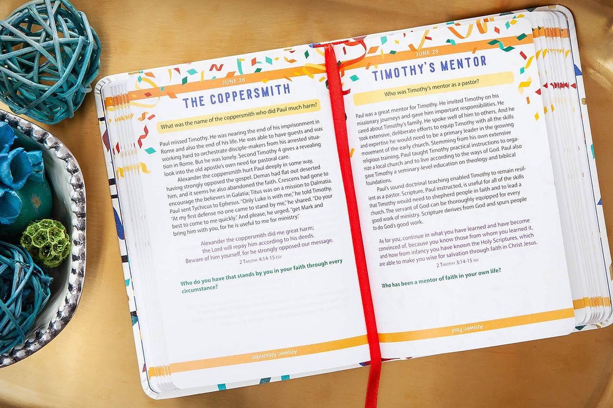 Open Bible trivia book with colorful text and a red ribbon on a wooden surface