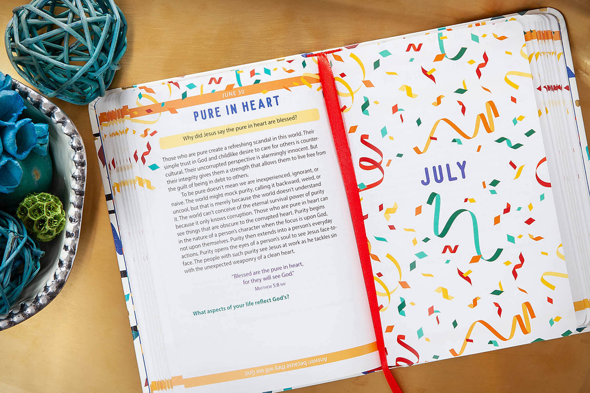 Open Bible devotional with colorful design on a wooden surface