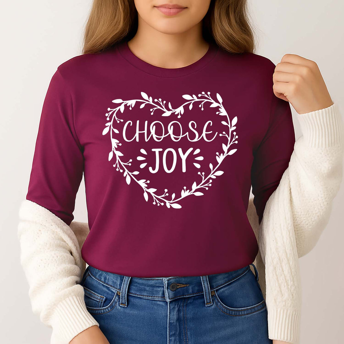 Woman wearing a maroon shirt with 'Choose Joy' text and a floral heart design