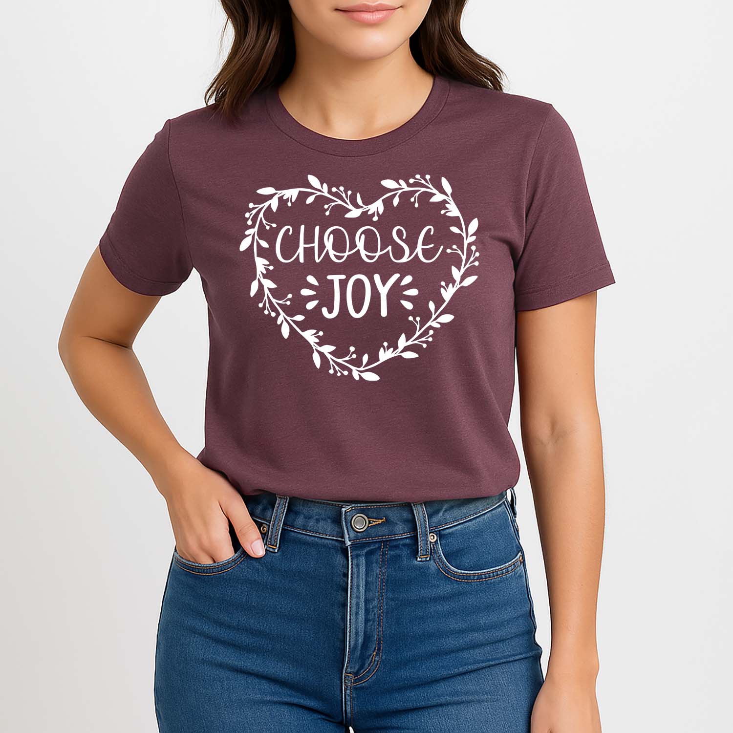 Person wearing a maroon t-shirt with 'Choose Joy' design on a plain background