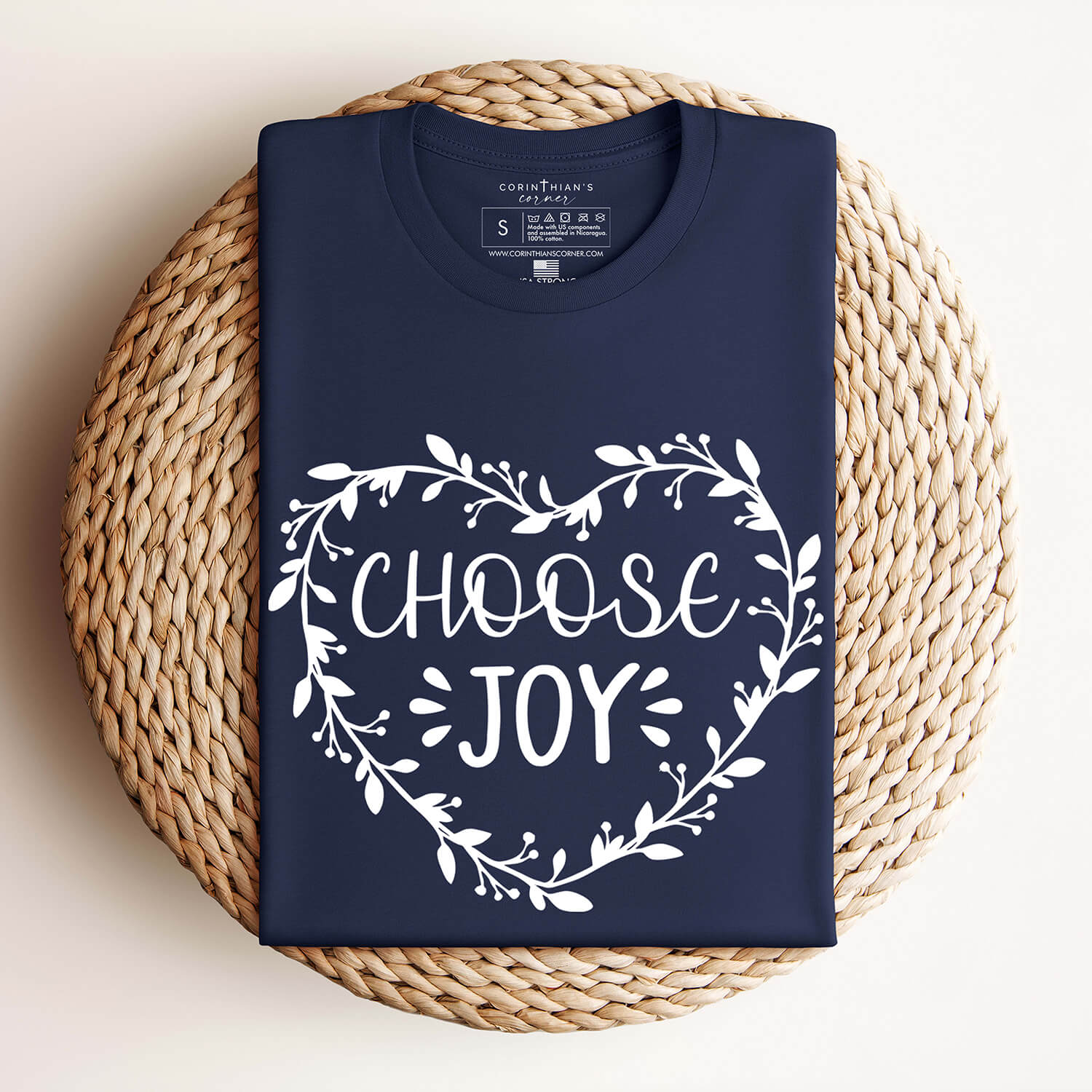 Limited edition Choose Joy crewneck in navy hanging against wall