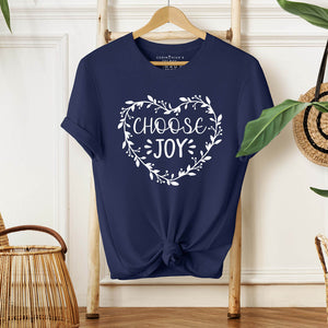 Limited edition Choose Joy crewneck in navy hanging against wall