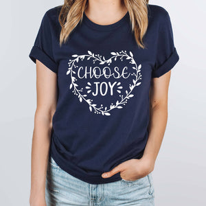 Young woman with hand in her pocket wearing a premium navy t-shirt with choose joy screenprinted on the front