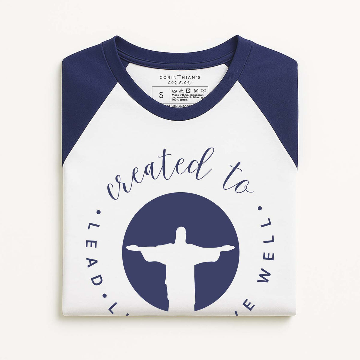 Created to lead live serve well graphic on a blue and white baseball tee