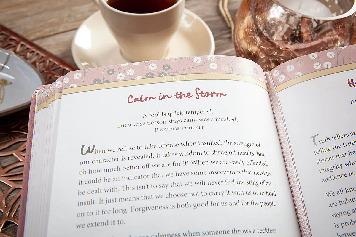 Open book with a quote on a wooden table with a cup of coffee.