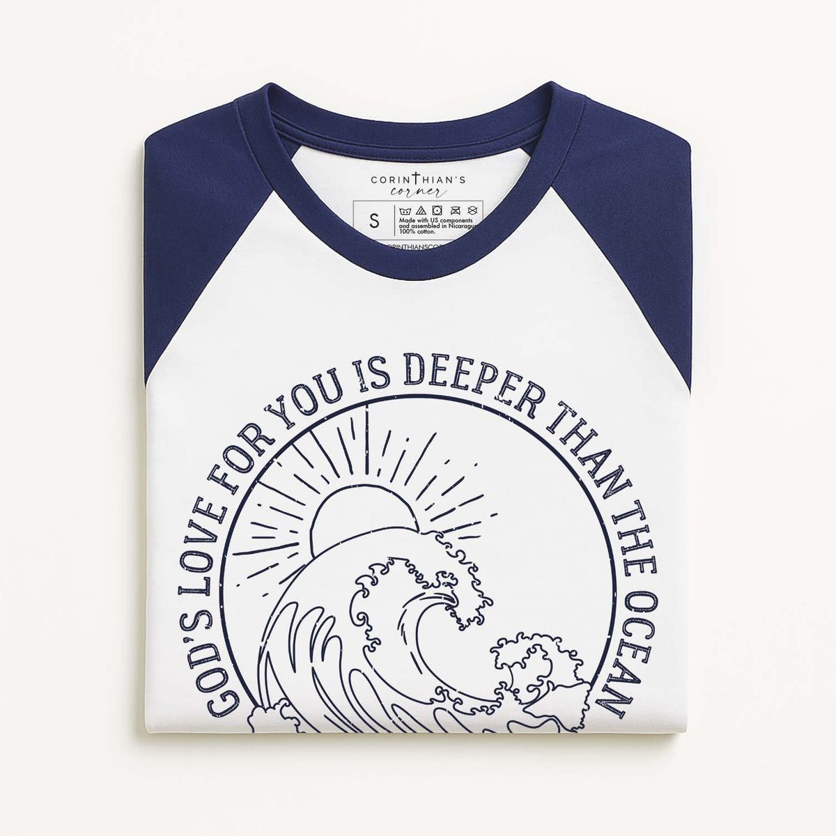 White and navy baseball shirt with ocean wave design and Biblical text on a white background