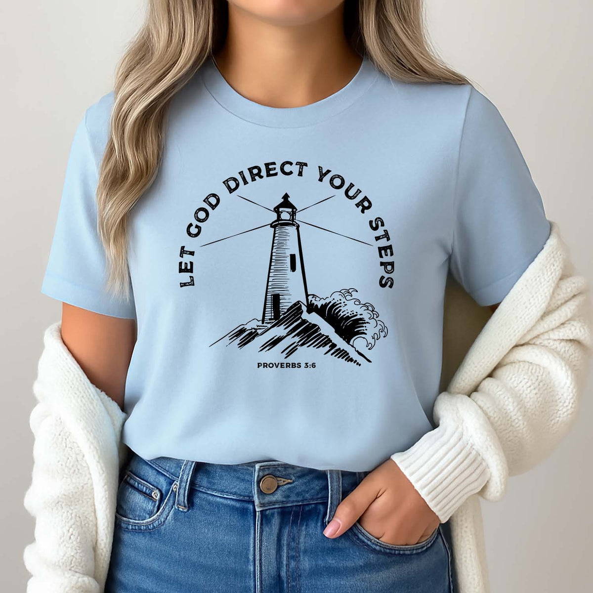 Woman wearing a light blue Christian t-shirt with a lighthouse design and Biblical text.