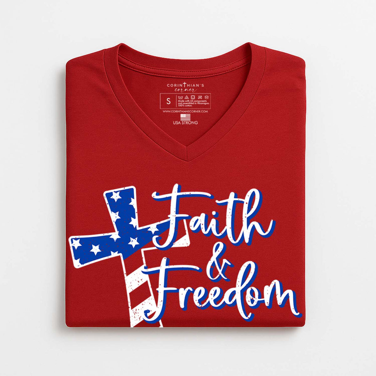 Folded red t-shirt with 'Faith & Freedom' design on a white background
