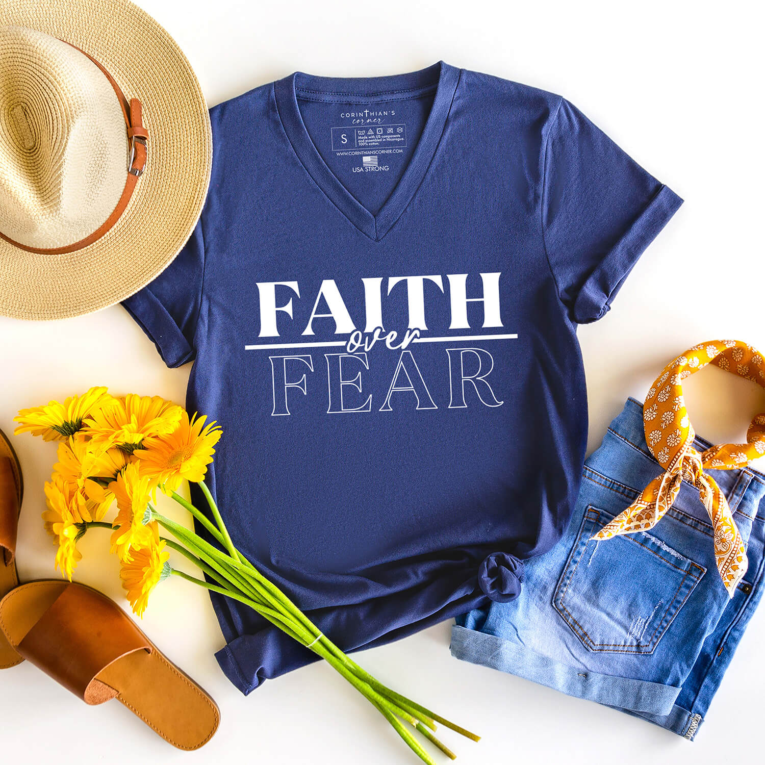Bold faith over fear graphic on a navy blue v-neck designed to inspire confidence in God's power