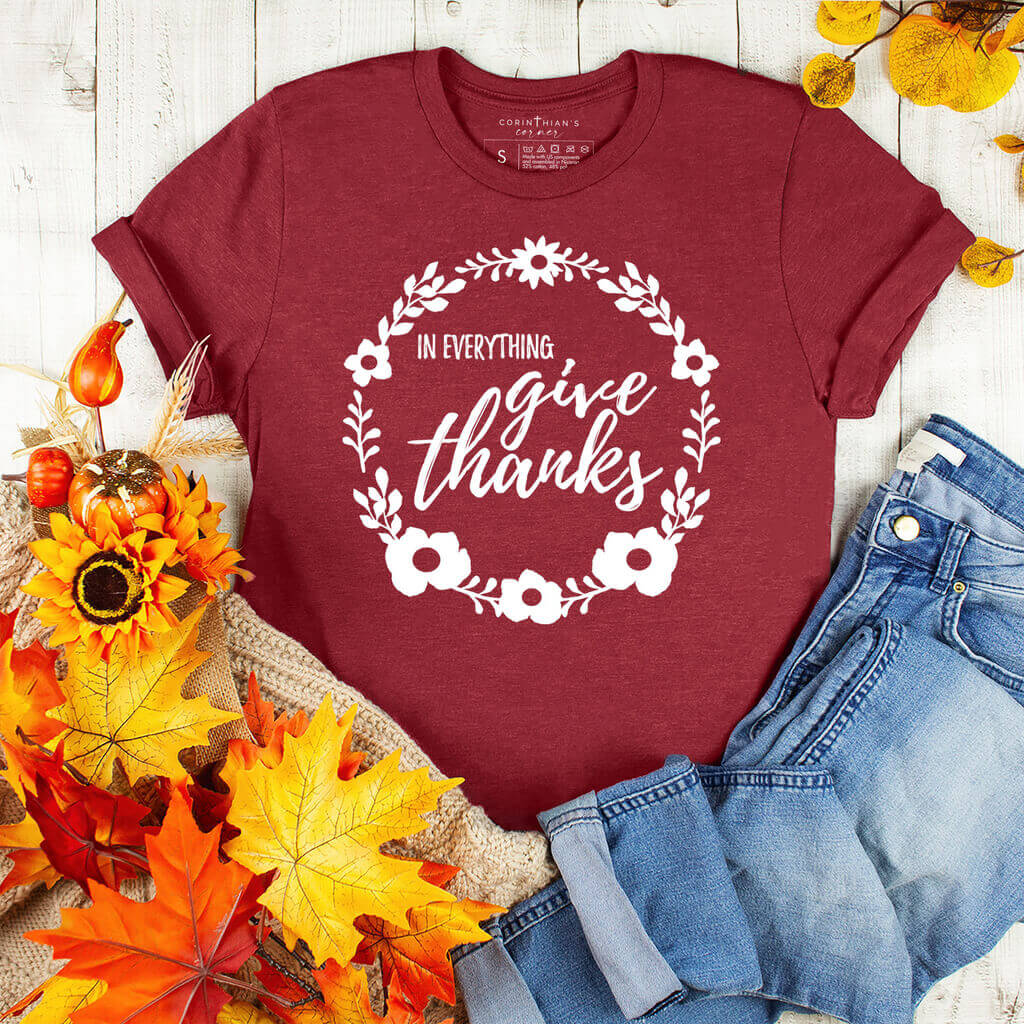 Fall leaves surrounding a cardinal t-shirt with a Christian Thanksgiving message from the scripture