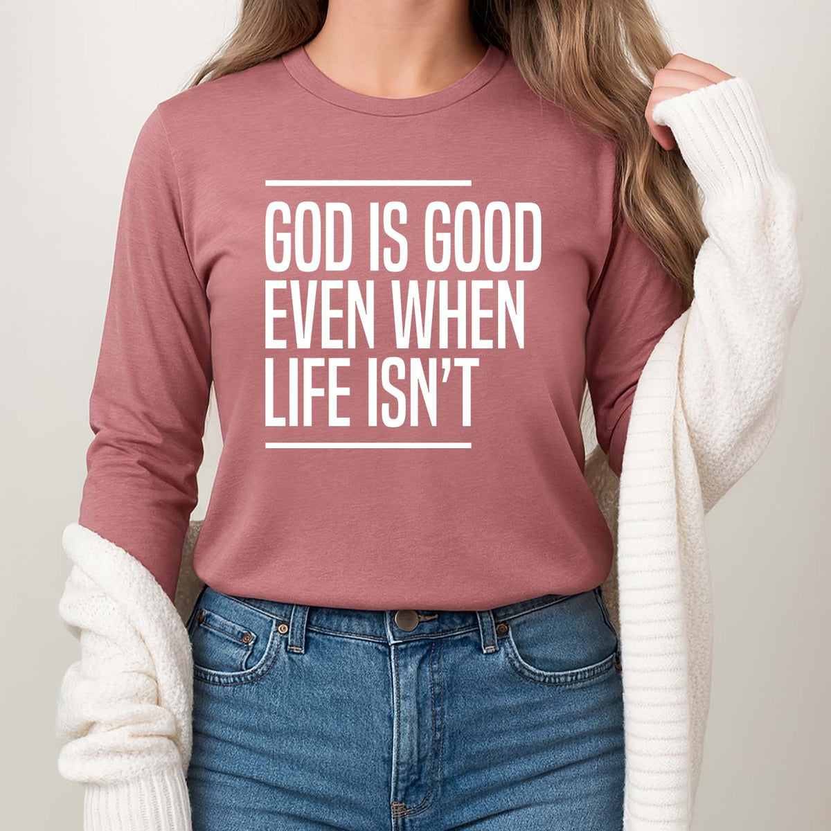 Young woman wearing a pink long-sleeve shirt with 'God is good even when life isn't' print