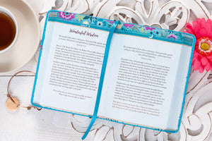 Floral notebook with a tea cup and decorative elements on a white surface