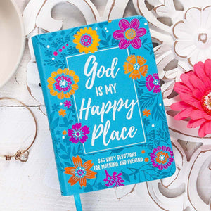 Blue devotional book with floral designs and 'God is my happy place' text on a decorative surface.
