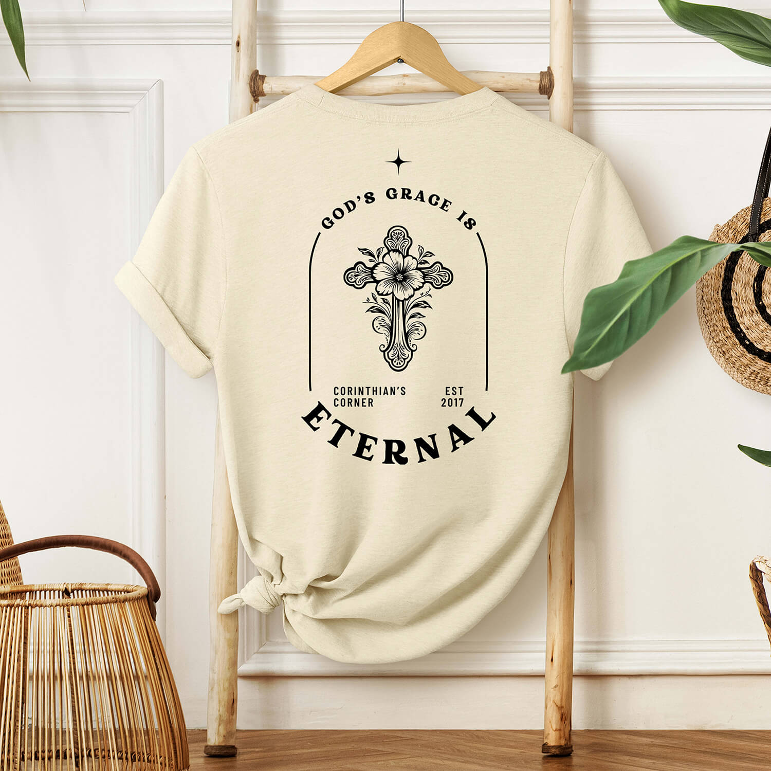 Ornate cross design on the left chest of a natural colored premium t-shirt