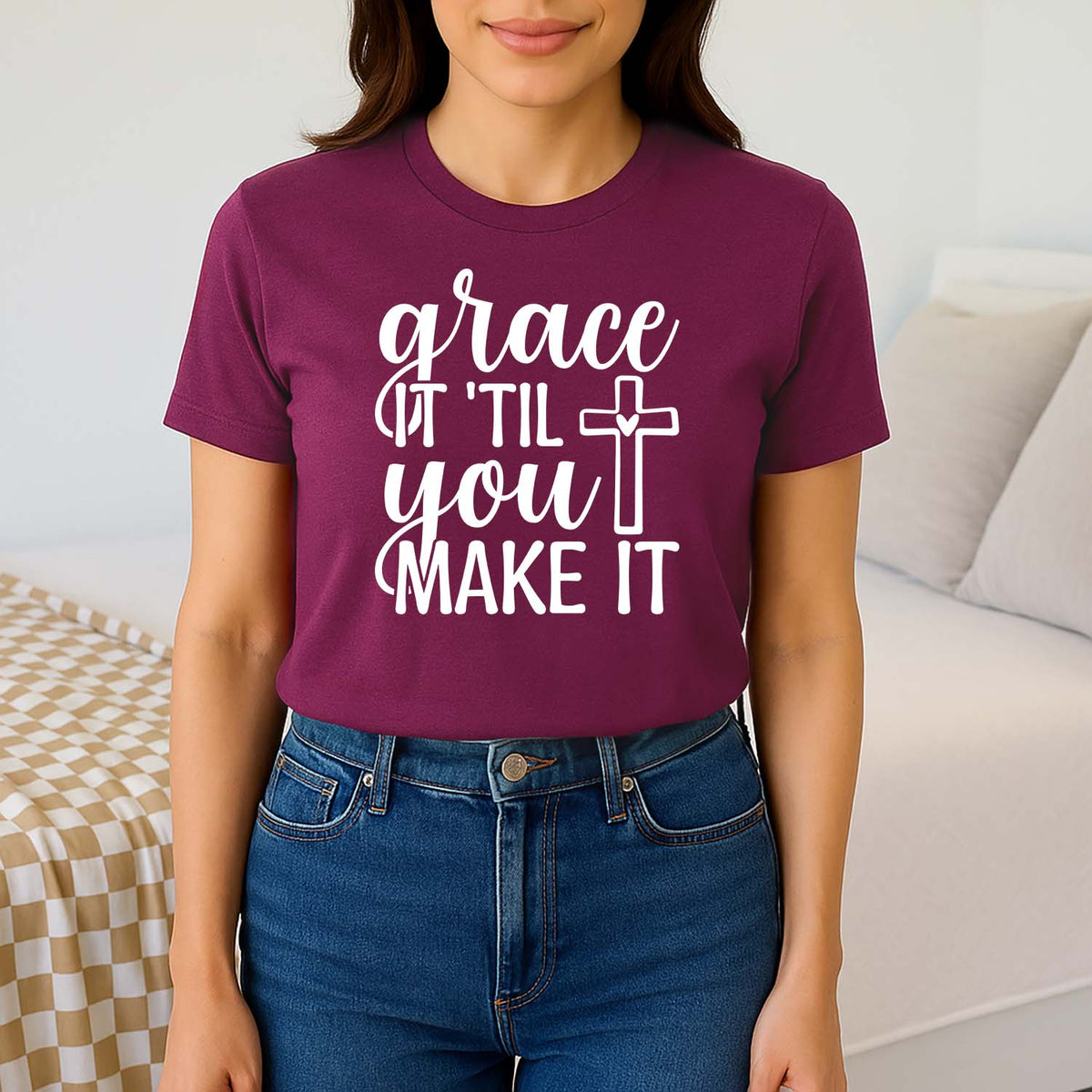 Woman wearing a maroon 'grace it til you make it' shirt with jeans