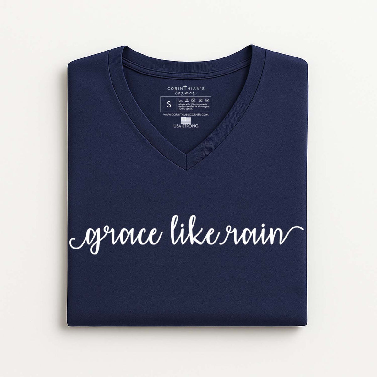 Folded navy blue V-neck t-shirt with 'grace like rain' text on a white background