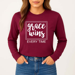 Maroon long sleeve shirt with 'grace wins EVERY TIME' text worn by a woman standing against a white background