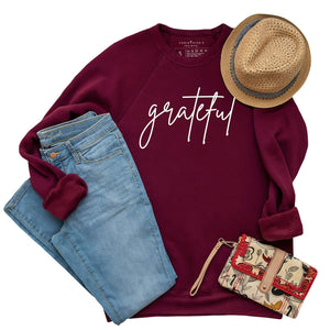 Simple white "grateful" print on a premium fleece sweatshirt in maroon