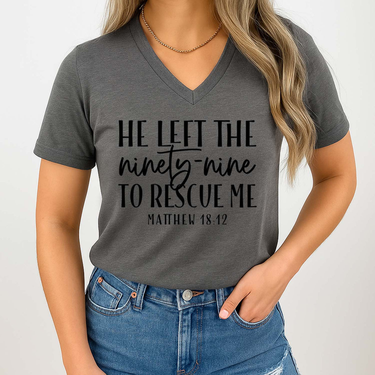 Person wearing a gray t-shirt with a Christian quote on a plain background